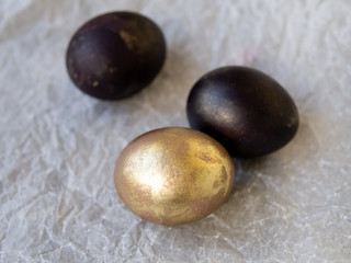 Black and gold eggs on white background. Easter holiday concept. Selective focus, copy space, close up.