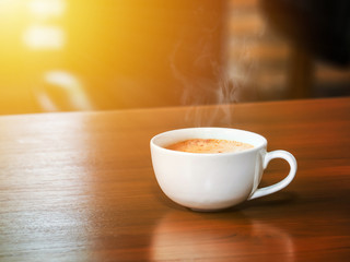 cup of hot flash coffee on wooden table in old style coffee shop with warming sunlight morning