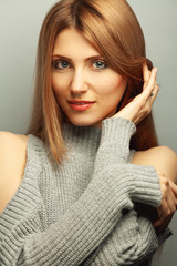 Girl Next Door, My fair lady concept. Close up portrait of 30 years old young woman smiling wearing knitted dress over gray background and thinking. Perfect smile. Studio shot