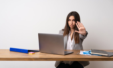 Business woman in a office making stop gesture denying a situation that thinks wrong