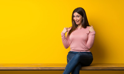 Young woman sitting on table with surprise facial expression