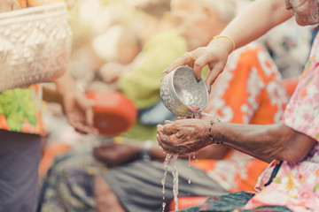Thai people celebrate Songkran by pouring water and giving garlands to elder senior or respected grandparents and elder and asked for blessings for celebrate Songkran in new year water festival