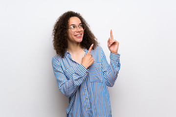 Dominican woman with striped shirt pointing with the index finger and looking up