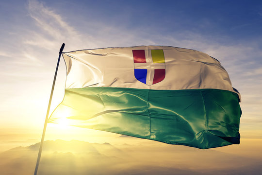 Rapla county of Estonia flag waving on the top sunrise mist fog