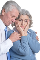 Portrait of sad senior couple posing on white background
