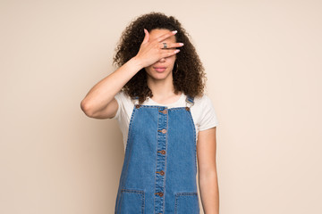 Dominican woman with overalls covering eyes by hands. Do not want to see something