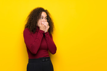 Dominican woman with turtleneck sweater covering mouth with hands