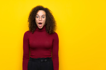 Dominican woman with turtleneck sweater with surprise and shocked facial expression