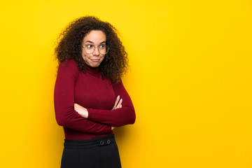 Dominican woman with turtleneck sweater making doubts gesture while lifting the shoulders