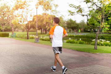 Unidentified middle aged man jogging in the park in morning.