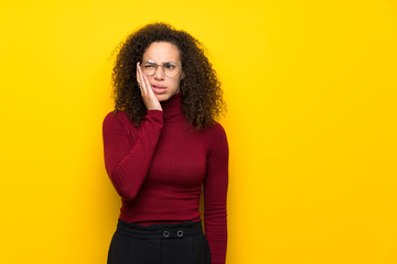 Dominican woman with turtleneck sweater with toothache