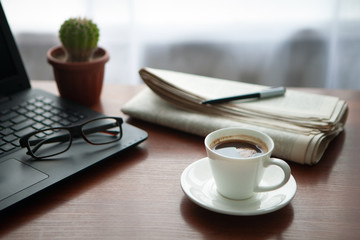 Newspaper with computer on table. Coffee break.