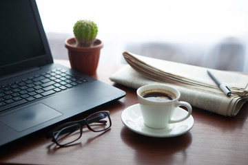 Newspaper with computer on table. Coffee break.