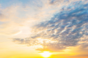 Sky blue and orange light of the sun through the clouds in the sky