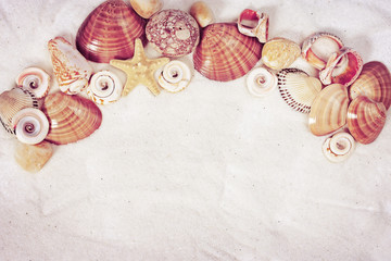 Composition of seashells and sea stones on sandy surface. Summer background.