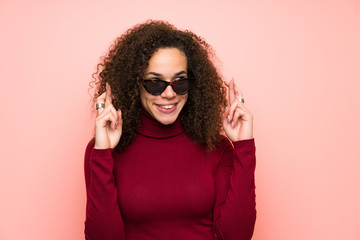 Dominican woman with turtleneck sweater with fingers crossing