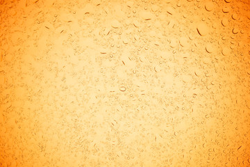 Rain droplets on yellow glass background, Water drops on yellow glass.