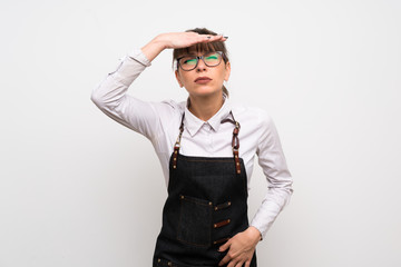 Young woman with apron looking far away with hand to look something