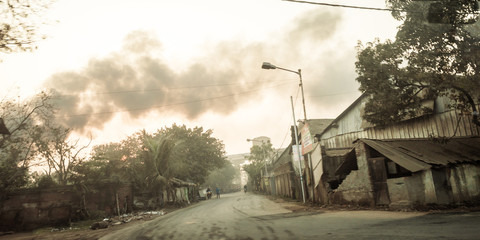 Kolkata, India - May 1, 2018 - Burning fire from garbage heap in industrial area, causing a large...
