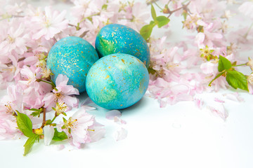 Easter background. Family traditional holidays. Painted eggs with flowering twigs on a light background. It's spring.