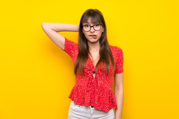 Obraz premium Young woman over yellow wall with confuse face expression