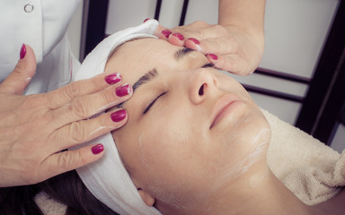 Relaxed woman lying on spa bed prepared for facial treatment