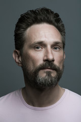 Fototapeta premium Fabulous at any age. Portrait of 40-year-old man standing over dark gray background. Close up. Classic style. Scar on forehead. Studio shot