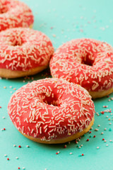 Donuts decorated with icing on blue background.