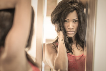portrait detail of a very sensual african american woman looking at herself in the mirror