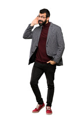 Fototapeta premium Handsome man with glasses listening to something by putting hand on the ear over isolated white background