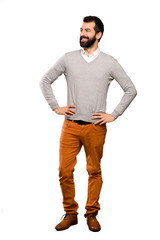 Fototapeta premium Handsome man posing with arms at hip and smiling over isolated white background