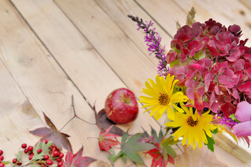 still life with beautiful colors of autumnal flowers on a wooden table
