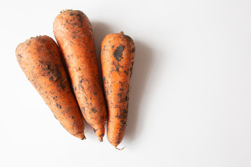 Unwashed carrot on white table