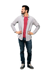 Fototapeta premium Full-length shot of Handsome man with beard posing with arms at hip and smiling over isolated white background