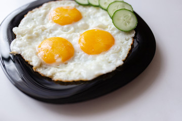 Breakfast. Fried eggs with bread and cucumbers