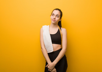 Obraz premium Young fitness girl dreaming of achieving goals and purposes