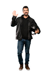 Fototapeta premium Full-length shot of Biker man saluting with hand with happy expression over isolated white background