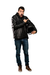 Full-length shot of Biker man surprised and pointing side over isolated white background