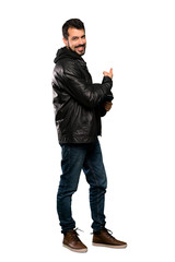 Naklejka premium Full-length shot of Biker man pointing back over isolated white background