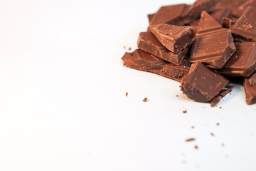 pieces of chocolate on white background with copy space