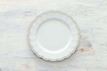 Top view of vintage white empty plate. Flat lay