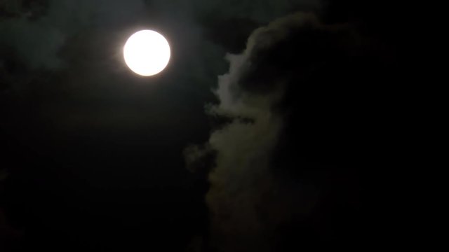 Der Mond zieht am Himmel entlang mit einem Schweif und verschwindet hinter Wolken