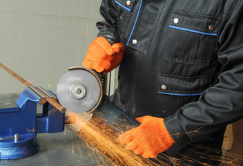 Industry worker cutting metal with grinder. Lots of glowing sparks