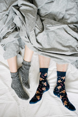 Feet in socks under a blanket in bed