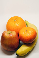 Orange mandarin banana and apple on white isolated background