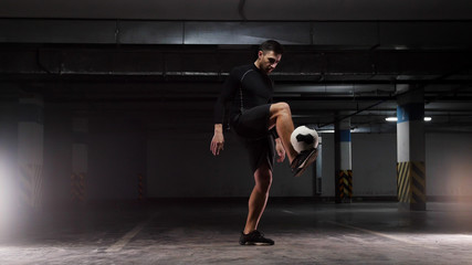 A young soccer man training the basic tricks with the ball Balancing the ball on the lifted feet