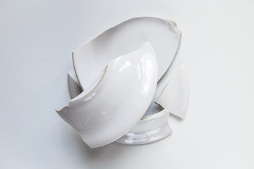 pile of broken white plate on light background