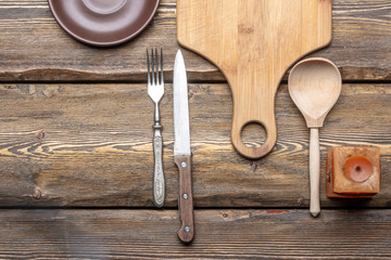 utensils with square candle and vintage cutlery on wooden background, top view 