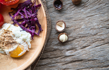 Breakfast consists of fried egg, pepper, sliced bread, tomato and purple cabbage serving in wooden...