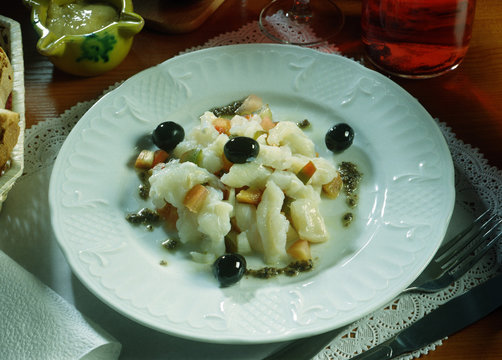 Plato de esqueixada de bacalao con tomate, pimienta negra y aceitunas.
